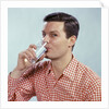 1960s Man Drinking Glass Water Wearing Red Checkered Shirt by Anonymous