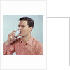 1960s Man Drinking Glass Water Wearing Red Checkered Shirt by Anonymous