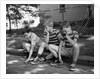 1970s Three Bored Boys Sitting On Curb All Wearing Striped Tee Shirts Shorts And Sneakers by Anonymous
