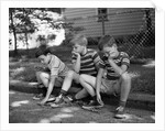 1970s Three Bored Boys Sitting On Curb All Wearing Striped Tee Shirts Shorts And Sneakers by Anonymous