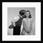 1950s 1960s Boy In Vest and Bow Tie Holding Valentine Candy Kissing Cheek Of Girl Making A Face by Anonymous