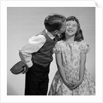 1950s 1960s Boy In Vest and Bow Tie Holding Valentine Candy Kissing Cheek Of Girl Making A Face by Anonymous