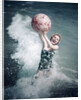 1950s Woman Jumping In Surf Holding Up Beach Ball by Anonymous