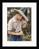 Boy Wearing Straw Hat Removing Hook From Mouth Of Fish Outdoor by Anonymous
