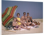 1960s Family On Sunny Beach Under Umbrella With Picnic Basket by Anonymous