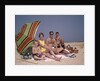 1960s Family On Sunny Beach Under Umbrella With Picnic Basket by Anonymous