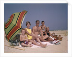 1960s Family On Sunny Beach Under Umbrella With Picnic Basket by Anonymous