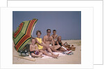 1960s Family On Sunny Beach Under Umbrella With Picnic Basket by Anonymous