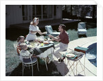 1950s Family In Backyard Having Picnic From Grill Near Swimming Pool by Anonymous