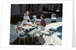 1950s Family In Backyard Having Picnic From Grill Near Swimming Pool by Anonymous