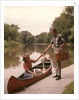 1960s Young Couple Loading Picnic Basket Thermos Into Canoe by Anonymous