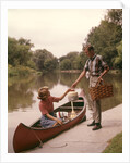 1960s Young Couple Loading Picnic Basket Thermos Into Canoe by Anonymous