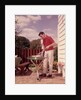 1960s Man Wearing Red Shirt Cooking Steak Outdoor On Backyard Grill by Anonymous