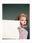 1960s Portrait Of Surprised Woman Peeking Around Sign Board by Anonymous