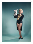 1960s Young Woman In Stage Magician Coat And Short Shorts Pulling Rabbit Out Of Top Hat by Anonymous
