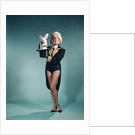 1960s Young Woman In Stage Magician Coat And Short Shorts Pulling Rabbit Out Of Top Hat by Anonymous