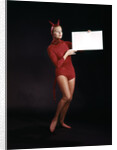 1960s Young Woman In Red Devil Costume Holding Sign Board In Hands by Anonymous
