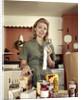 1960s Young Housewife While Checking Grocery Shopping Receipt In Kitchen by Anonymous