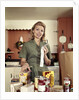 1960s Young Housewife While Checking Grocery Shopping Receipt In Kitchen by Anonymous