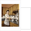 1960s Woman Housewife Wearing An Apron Stirring Cooking Pot At Kitchen Stove by Anonymous