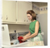 1970s Woman Housewife Homemaker Wearing Apron Loading Laundry Into Washing Machine by Anonymous