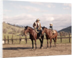 1970s Father And Son Sitting Together On Horses By Corral Wearing Hats by Anonymous