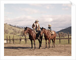 1970s Father And Son Sitting Together On Horses By Corral Wearing Hats by Anonymous