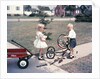 1950s Little Girl Sister Holding Doll Watching Little Boy Brother Repair Tricycle by Anonymous