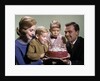 1960s Mother And Father Holding Birthday Cake And Sons Blowing Out Candles by Anonymous