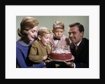 1960s Mother And Father Holding Birthday Cake And Sons Blowing Out Candles by Anonymous