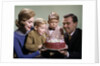 1960s Mother And Father Holding Birthday Cake And Sons Blowing Out Candles by Anonymous