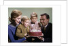1960s Mother And Father Holding Birthday Cake And Sons Blowing Out Candles by Anonymous