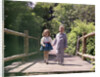 1960s Little Boy And Girl Holding Hands And Walking Across Wooden Footbridge by Anonymous