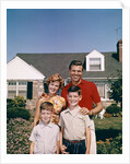 1960s Portrait Family Father Mother Two Sons Standing Together In Front Of Suburban House by Anonymous