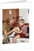 1970s Mother Giving First-Aid Putting Band-Aid On Knee Of Son In Kitchen by Anonymous