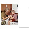 1970s Mother Giving First-Aid Putting Band-Aid On Knee Of Son In Kitchen by Anonymous