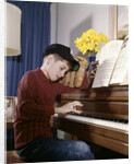 1960s 1970s Impatient Annoyed Looking Boy With Baseball Cap And Glove Practicing Piano Lesson by Anonymous