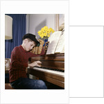 1960s 1970s Impatient Annoyed Looking Boy With Baseball Cap And Glove Practicing Piano Lesson by Anonymous