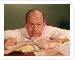 1960s Angry Man Businessman Desk Full Of Bills Paper Work Office Stress Frustration by Anonymous