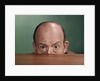 1960s Balding Man Peeking Over Desktop With Only Top Half Of Head Showing by Anonymous