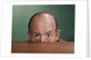 1960s Balding Man Peeking Over Desktop With Only Top Half Of Head Showing by Anonymous
