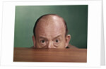 1960s Balding Man Peeking Over Desktop With Only Top Half Of Head Showing by Anonymous