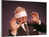 1960s Blindfolded Senior Man Businessman Arms Reaching Grasping Feeling Way by Anonymous