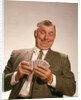 1960s Satisfied Man Looking At Hand Of Playing Cards by Anonymous