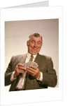1960s Satisfied Man Looking At Hand Of Playing Cards by Anonymous
