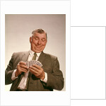 1960s Satisfied Man Looking At Hand Of Playing Cards by Anonymous