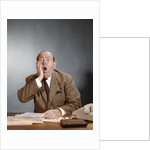 1960s Shocked Balding Executive With Hand To Cheek Sitting At Desk by Anonymous