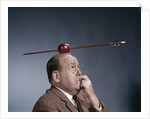 1960s Anxious Business Man Biting Finger With Nails Arrow Shot Through Apple On Of His Top Head by Anonymous