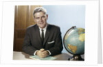 1960s Portrait Man Businessman Sitting At Desk Next To Globe Of The Earth by Anonymous