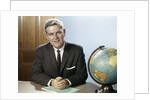 1960s Portrait Man Businessman Sitting At Desk Next To Globe Of The Earth by Anonymous
